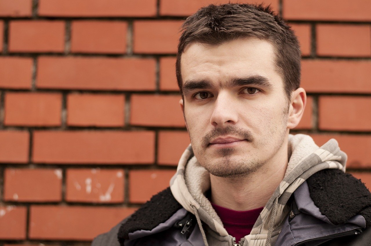 man in front of brick wall